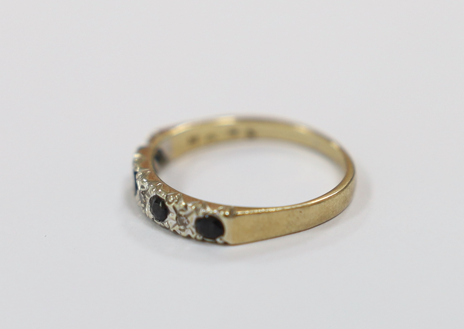 A modern 9ct gold, four stone sapphire and three stone diamond chip set half hoop ring, size N, gross weight 2 grams.